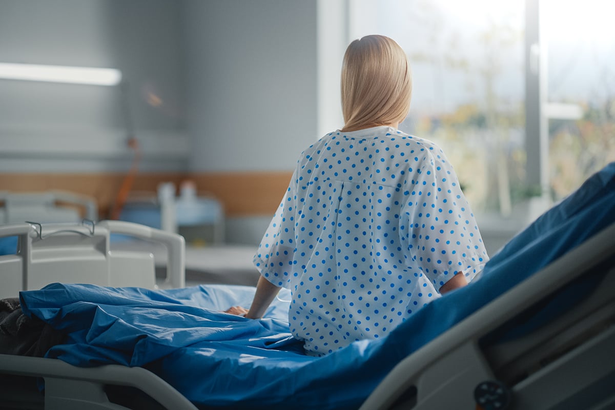 beautiful caucasian female patient sitting on a bed beautiful caucasian female patient sitting on a bed