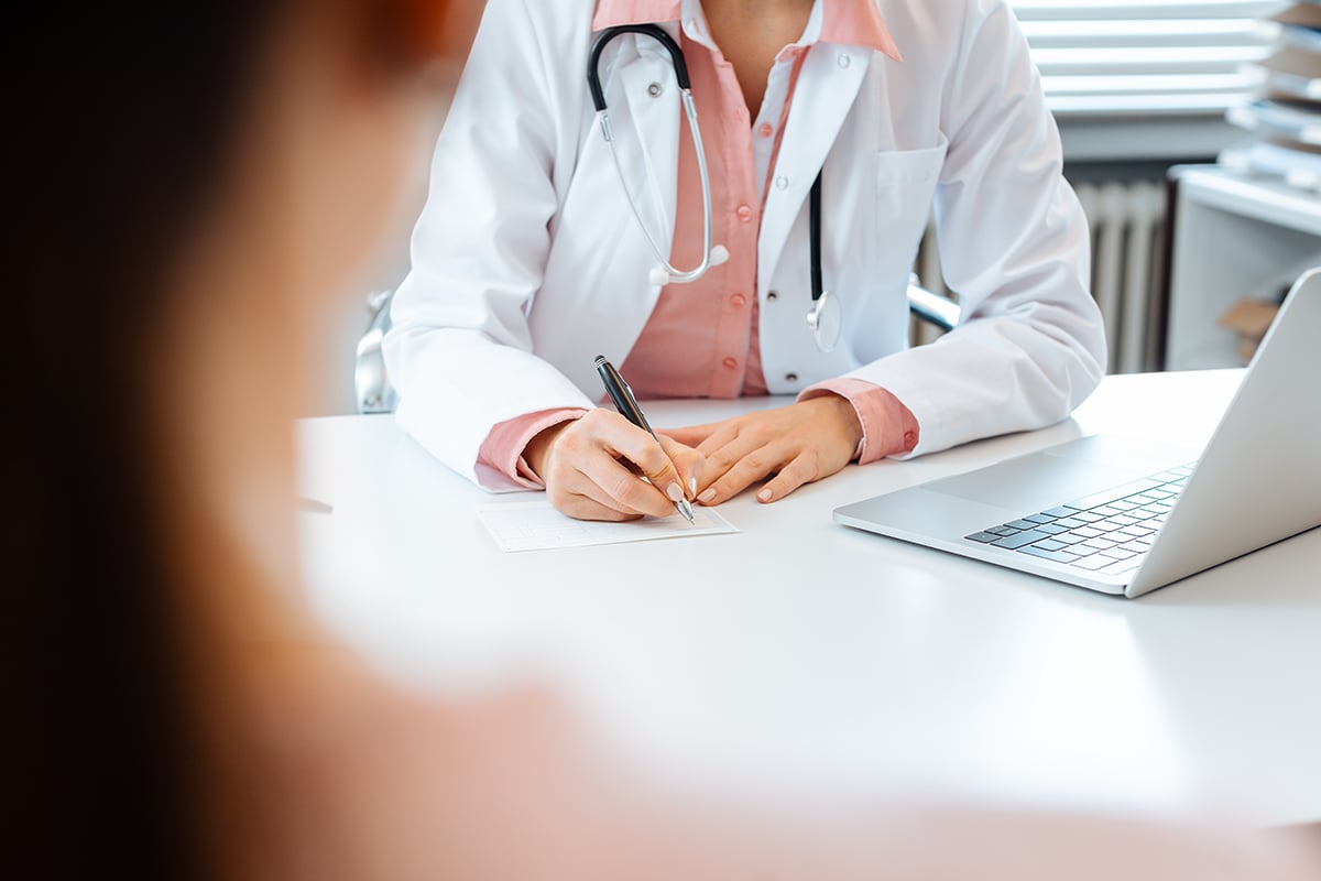 close up of doctor taking notes while having appointment with patient close up of doctor taking notes while having appointment with patient