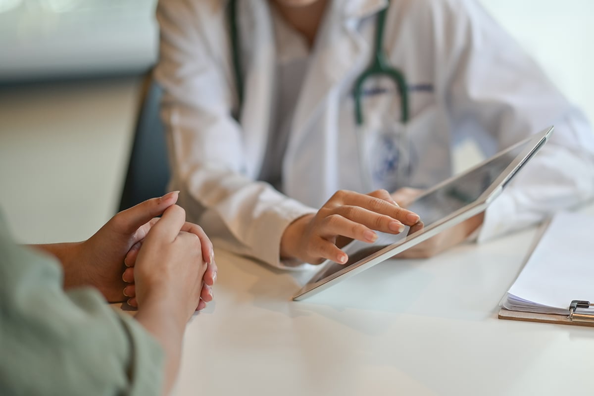 shot of a doctor showing a patient some information on a digital tablet shot of a doctor showing a patient some information on a digital tablet