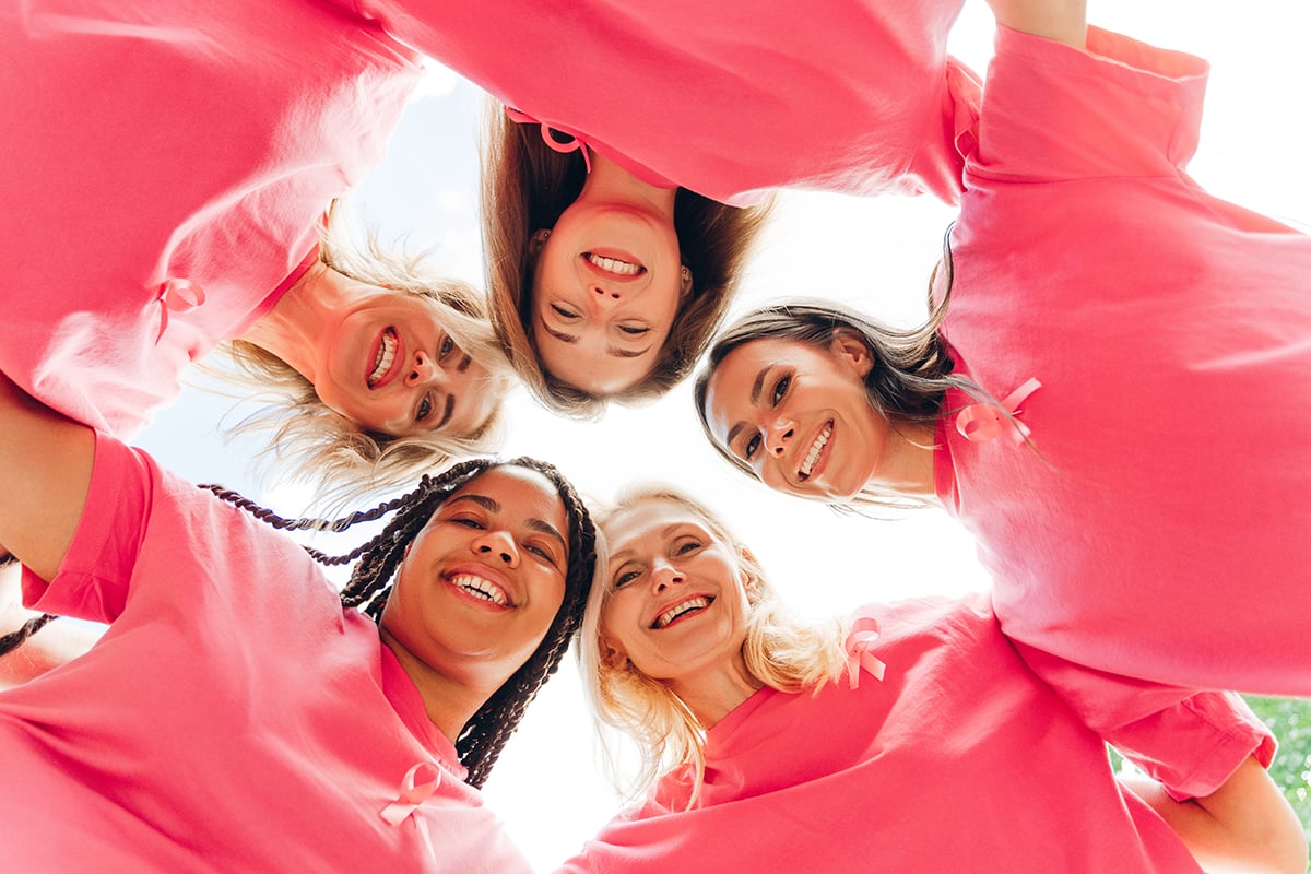 smiling women wearing pink ribbon supporting breast cancer awareness smiling women wearing pink ribbon supporting breast cancer awareness