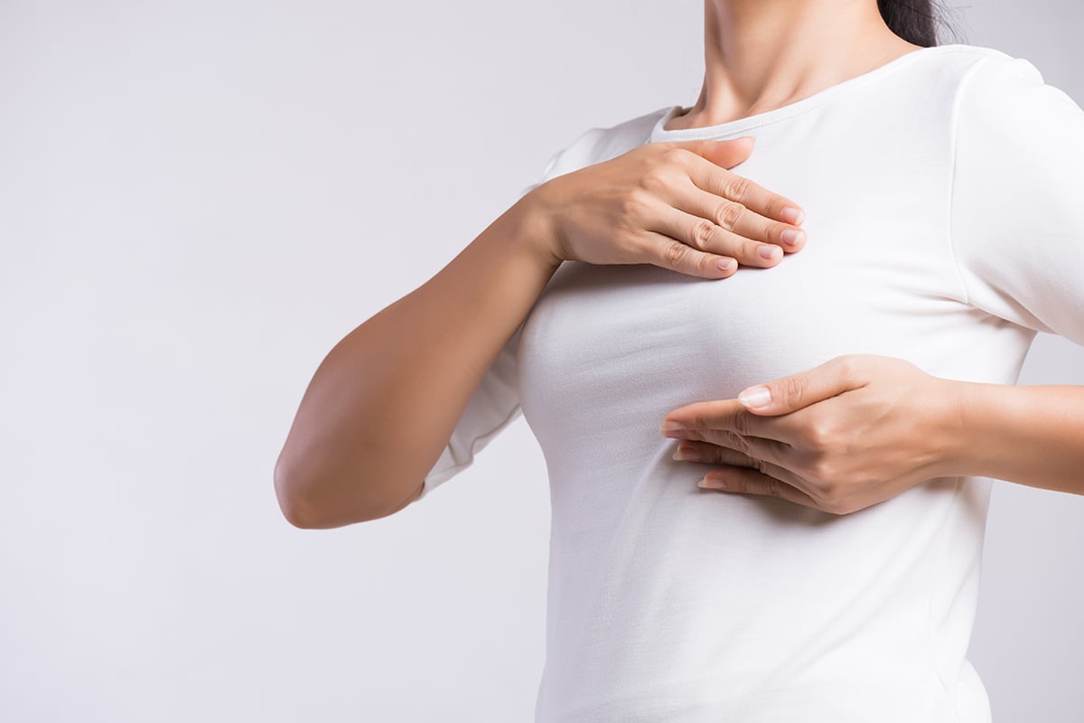 woman hand checking lumps on her breast for signs of breast cancer woman hand checking lumps on her breast for signs of breast cancer