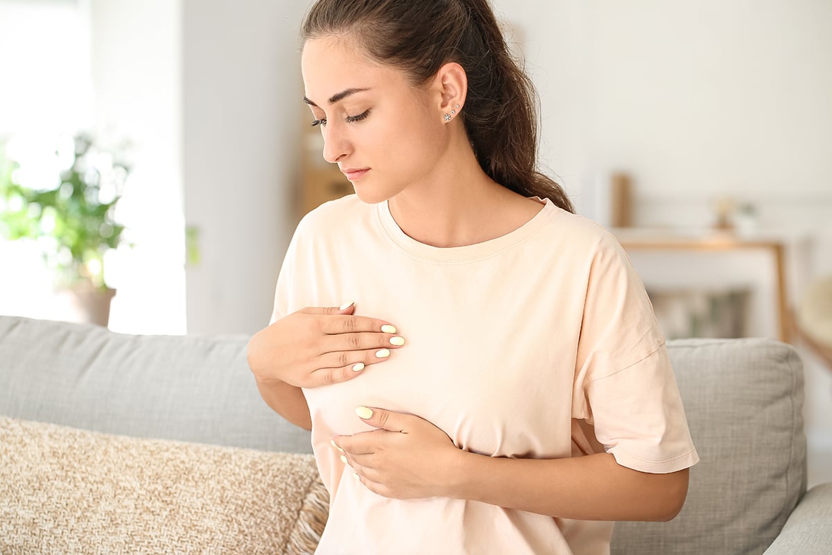 young woman suffering from breast pain at home young woman suffering from breast pain at home